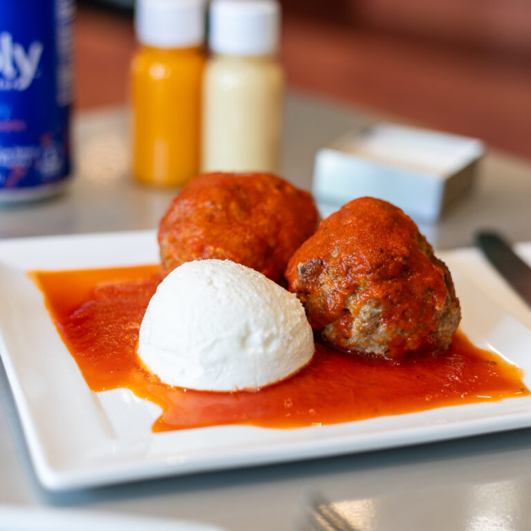 two meatballs and a scoop of ricotta appetizer with plum tomato sauce