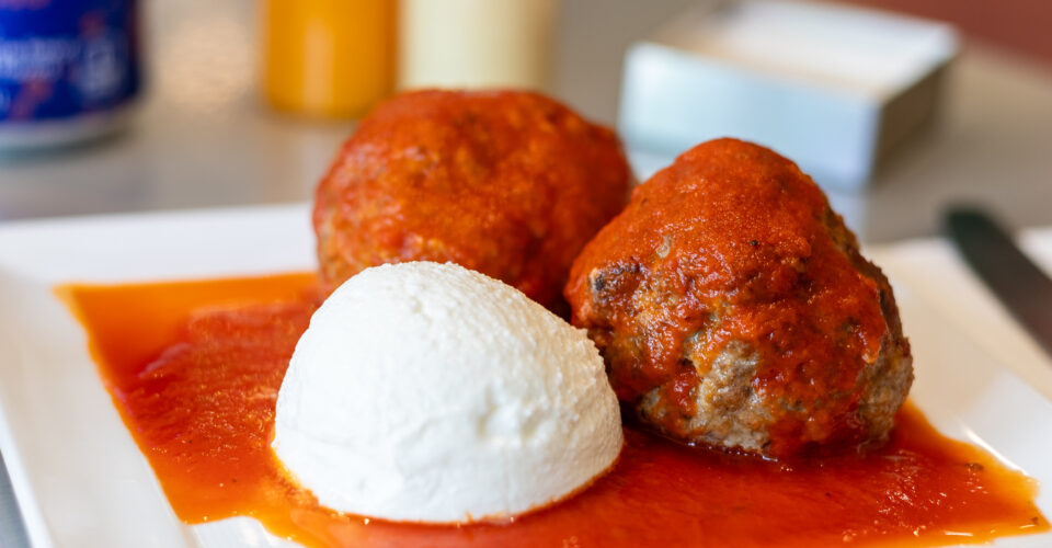 two meatballs and a scoop of ricotta appetizer with plum tomato sauce